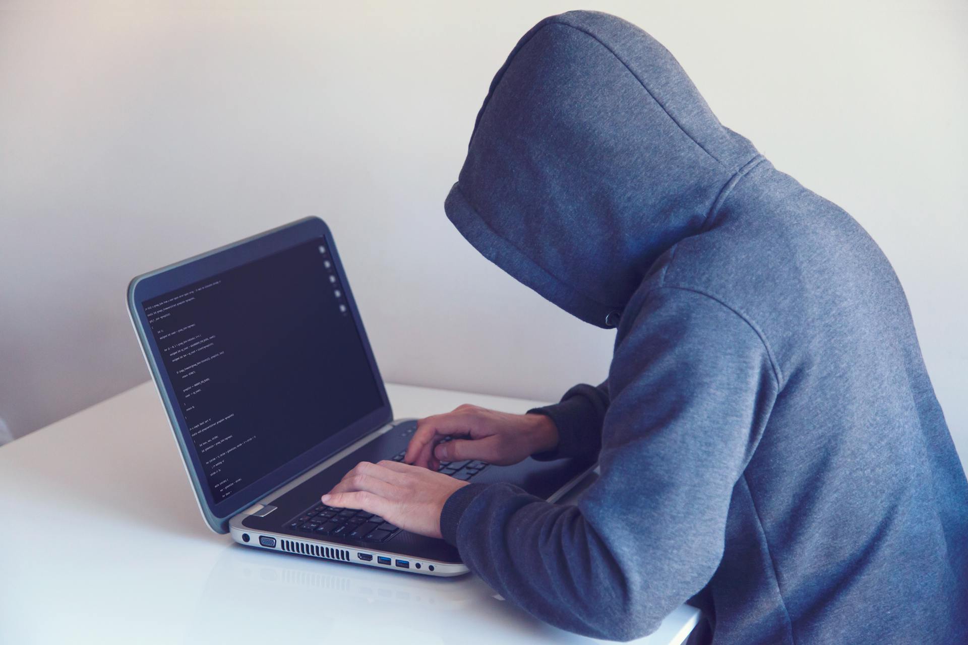 Anonieme hacker en oplichter spoof website achter computer